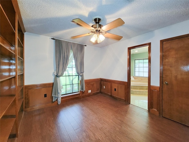3 Thunderbird Cir, Baytown, TX 77521 - empty room featuring wainscoting, wood finished floors, a textured ceiling, and a ceiling fan