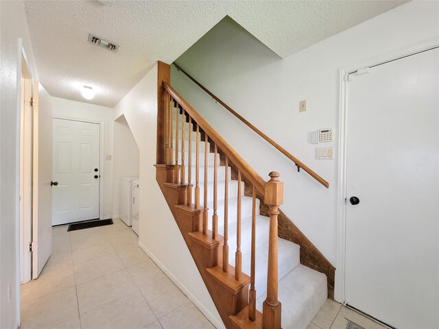 3 Thunderbird Cir, Baytown, TX 77521 - stairway with washer and dryer, a textured ceiling, and tile patterned floors
