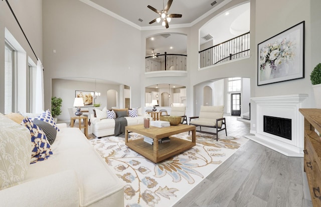 12611 Faded Sky Ct, Cypress, TX 77433 - living room with arched walkways, ceiling fan, a fireplace, crown molding, and wood finished floors