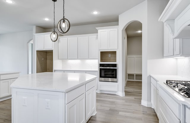 12611 Faded Sky Ct, Cypress, TX 77433 - kitchen with stainless steel appliances, arched walkways, light wood-type flooring, white cabinets, and recessed lighting