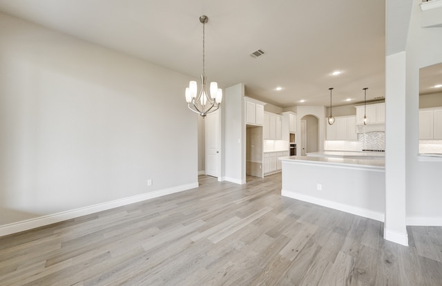 12611 Faded Sky Ct, Cypress, TX 77433 - kitchen featuring recessed lighting, arched walkways, light wood-style flooring, backsplash, and a chandelier