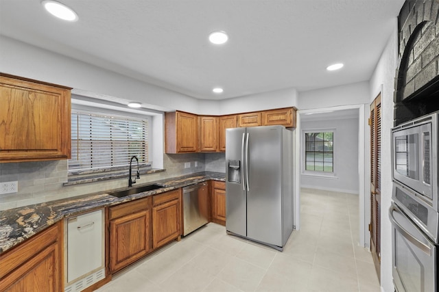12611 Old River Dr, Baytown, TX 77523 - kitchen with appliances with stainless steel finishes, brown cabinetry, backsplash, plenty of natural light, and recessed lighting