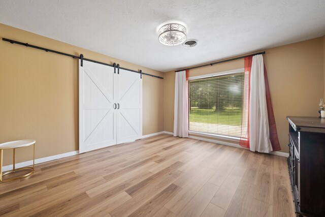 5254 State Highway 146 S, Livingston, TX 77351 - unfurnished bedroom featuring light wood-type flooring and a barn door