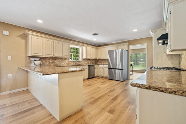 5254 State Highway 146 S, Livingston, TX 77351 - kitchen featuring stainless steel appliances, a peninsula, light wood finished floors, decorative backsplash, and recessed lighting