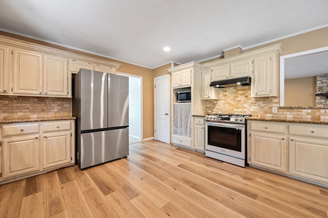 5254 State Highway 146 S, Livingston, TX 77351 - kitchen with appliances with stainless steel finishes, under cabinet range hood, ornamental molding, light wood-style floors, and tasteful backsplash