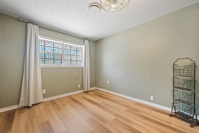 5254 State Highway 146 S, Livingston, TX 77351 - unfurnished room featuring light wood finished floors, a chandelier, and a textured ceiling