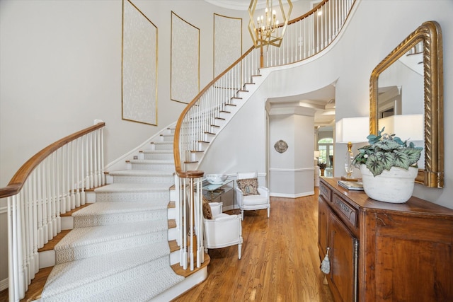 333 Sugarberry Cir, Houston, TX 77024 - stairs featuring wood finished floors, a towering ceiling, and a chandelier