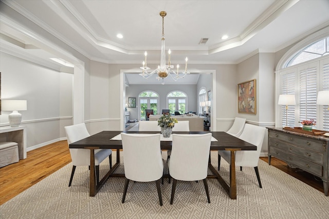 333 Sugarberry Cir, Houston, TX 77024 - dining space featuring a tray ceiling, wood finished floors, a chandelier, and ornamental molding