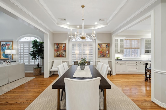 333 Sugarberry Cir, Houston, TX 77024 - dining space featuring a chandelier, a raised ceiling, light wood-type flooring, and ornamental molding