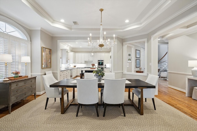 333 Sugarberry Cir, Houston, TX 77024 - dining space featuring a chandelier, light wood finished floors, a raised ceiling, stairway, and ornamental molding