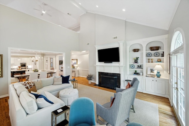 333 Sugarberry Cir, Houston, TX 77024 - living area with light wood finished floors, high vaulted ceiling, a fireplace with flush hearth, ceiling fan, and a chandelier