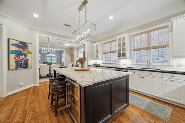 333 Sugarberry Cir, Houston, TX 77024 - kitchen with a kitchen island, a chandelier, white cabinetry, a breakfast bar, and wine cooler