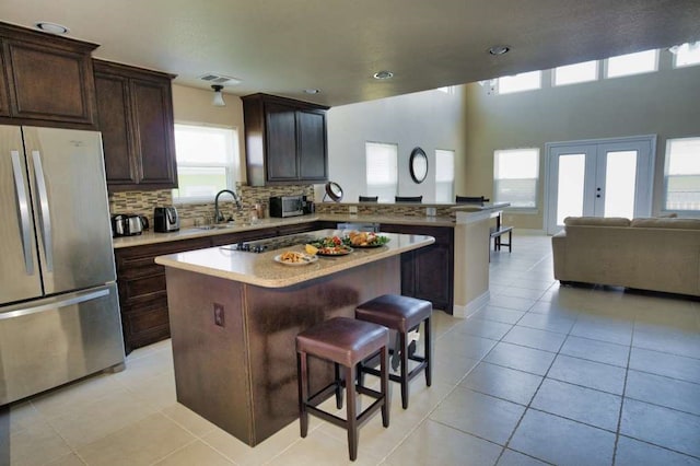 2028 County Road 201, Sargent, TX 77414 - kitchen featuring freestanding refrigerator, open floor plan, a breakfast bar, a kitchen island, and a peninsula