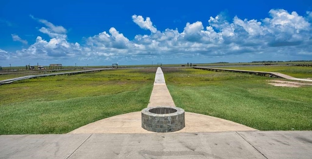 2028 County Road 201, Sargent, TX 77414 - view of green lawn with a fire pit and a view of countryside