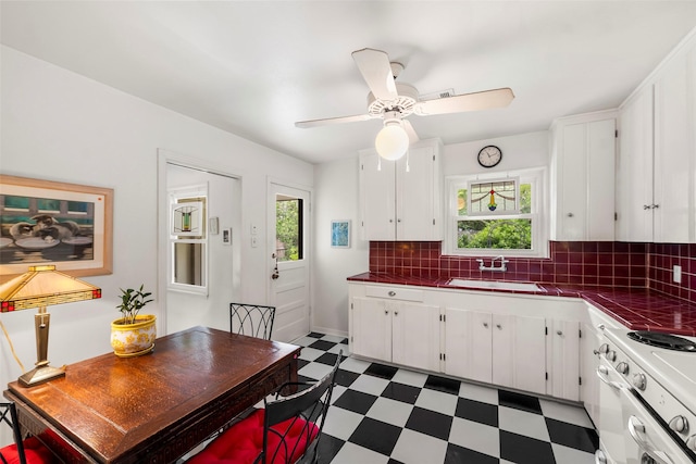 2114 Saxon Dr, Houston, TX 77018 - kitchen featuring tile countertops, light floors, white cabinetry, and tasteful backsplash