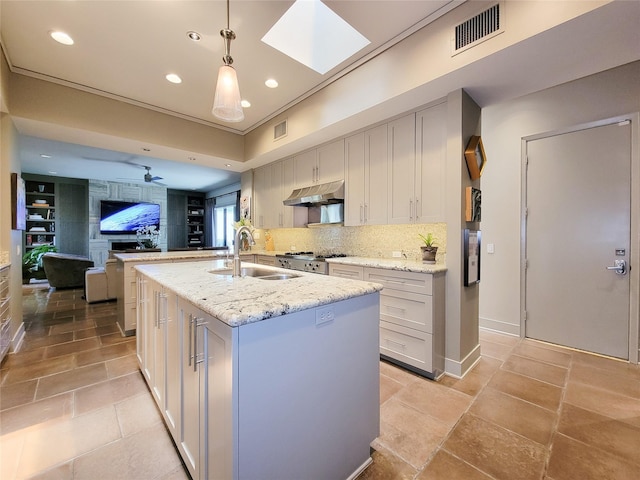 3124 Mid Ln, Houston, TX 77027 - kitchen featuring under cabinet range hood, decorative backsplash, a center island with sink, recessed lighting, and open floor plan