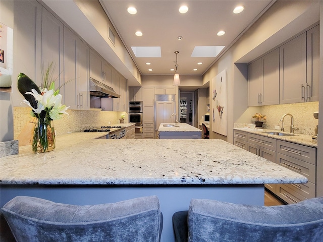 3124 Mid Ln, Houston, TX 77027 - kitchen with under cabinet range hood, paneled built in refrigerator, decorative backsplash, gray cabinetry, and recessed lighting