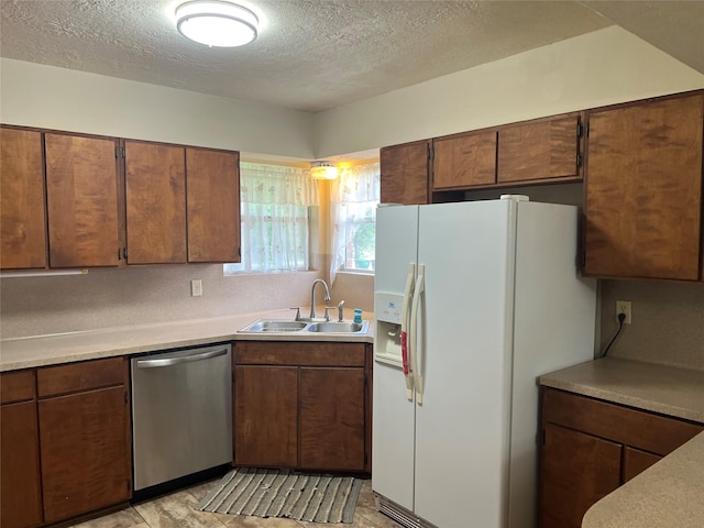 14027 Ambrose St, Houston, TX 77045 - kitchen featuring white refrigerator with ice dispenser, dishwasher, a textured ceiling, light countertops, and brown cabinets