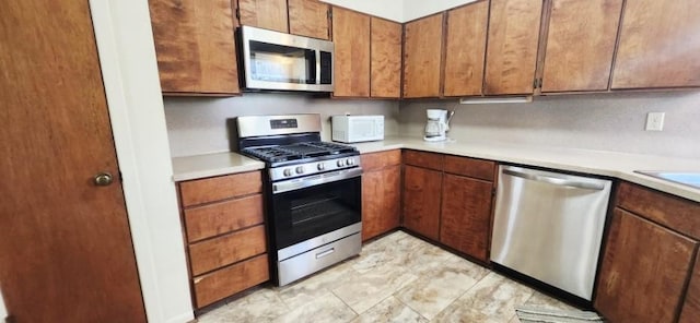 14027 Ambrose St, Houston, TX 77045 - kitchen featuring appliances with stainless steel finishes, light countertops, and brown cabinets