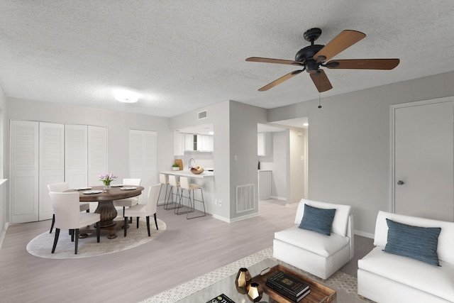 2212 Shadowdale Dr Unit 358, Houston, TX 77043 - living room with light wood-style flooring, a textured ceiling, and a ceiling fan
