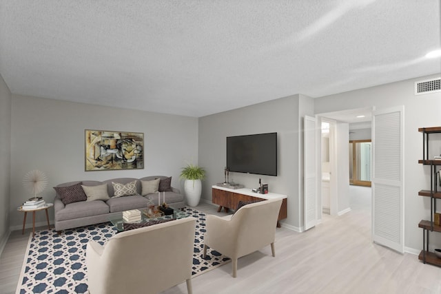 2212 Shadowdale Dr Unit 358, Houston, TX 77043 - living room featuring light wood-style floors, a textured ceiling, and recessed lighting