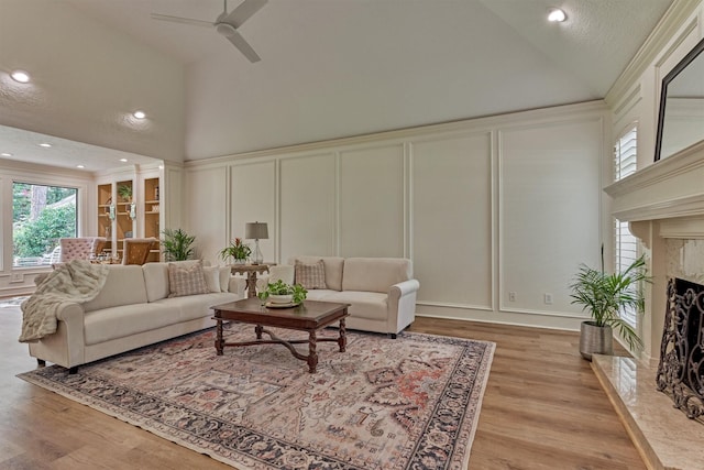 23119 Hampton Forest Ln, Spring, TX 77389 - living room featuring a decorative wall, light wood-style floors, a high end fireplace, a ceiling fan, and recessed lighting