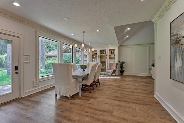 23119 Hampton Forest Ln, Spring, TX 77389 - dining area featuring a decorative wall, a textured ceiling, wood finished floors, ornamental molding, and recessed lighting