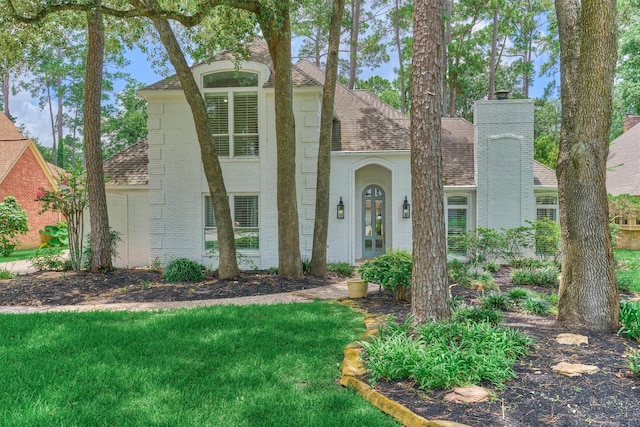 23119 Hampton Forest Ln, Spring, TX 77389 - view of front of home featuring a shingled roof, brick siding, a chimney, and a front yard