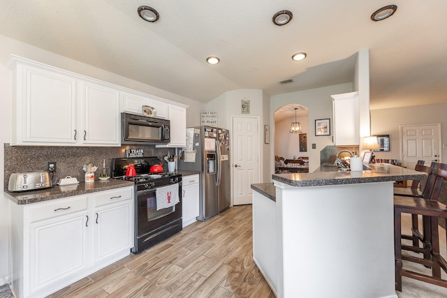 8114 Rushing Stream Ct, Tomball, TX 77375 - kitchen featuring black appliances, a breakfast bar, decorative backsplash, white cabinetry, and arched walkways