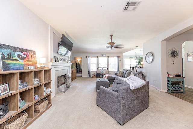 8114 Rushing Stream Ct, Tomball, TX 77375 - living area with a ceiling fan, a tile fireplace, light colored carpet, and arched walkways