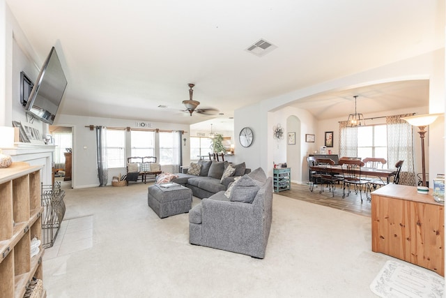 8114 Rushing Stream Ct, Tomball, TX 77375 - living area featuring arched walkways, light carpet, a ceiling fan, and a fireplace with flush hearth