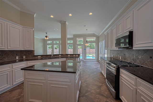 3631 Rocky Ledge Ln, Katy, TX 77494 - kitchen featuring appliances with stainless steel finishes, plenty of natural light, dark countertops, crown molding, and white cabinetry