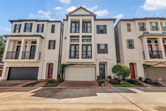 2206 Hilshire Glen Ct, Houston, TX 77080 - view of front of home featuring stucco siding, decorative driveway, a balcony, and a garage