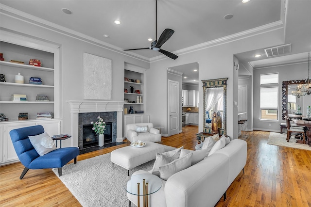 2206 Hilshire Glen Ct, Houston, TX 77080 - living room with ornamental molding, light wood-style flooring, a ceiling fan, a tile fireplace, and built in features