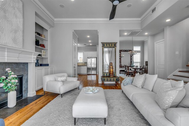 2206 Hilshire Glen Ct, Houston, TX 77080 - living room with crown molding, wood finished floors, healthy amount of natural light, a fireplace, and built in shelves