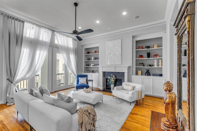 2206 Hilshire Glen Ct, Houston, TX 77080 - living area featuring built in features, ceiling fan, light wood-style floors, a premium fireplace, and ornamental molding