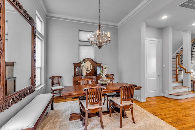 2206 Hilshire Glen Ct, Houston, TX 77080 - dining room with stairway, light wood finished floors, a chandelier, ornamental molding, and recessed lighting