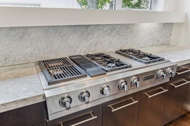 1728 Michigan St Unit C, Houston, TX 77006 - kitchen view of dark brown cabinetry, stainless steel gas stovetop, tasteful backsplash, and light stone counters