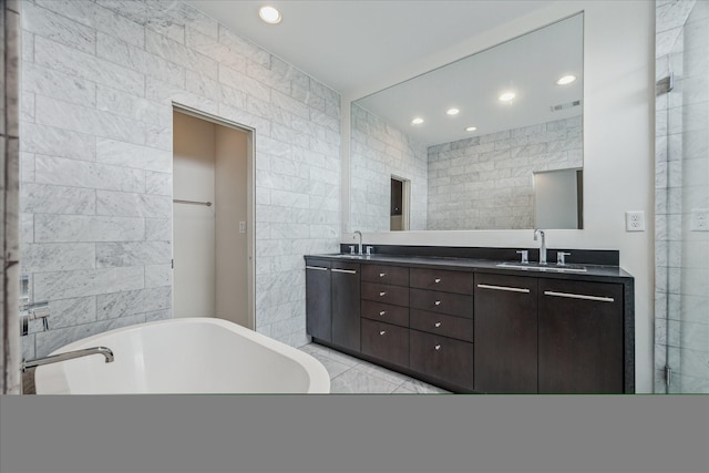 1728 Michigan St Unit C, Houston, TX 77006 - full bathroom featuring tile walls, a freestanding tub, recessed lighting, double vanity, and tile patterned flooring