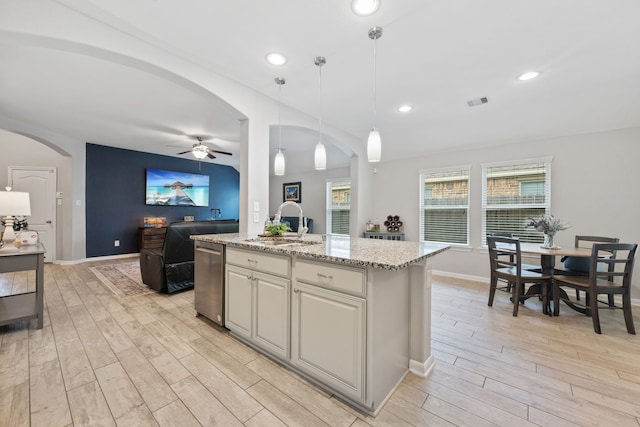 16863 Big Reed Dr, Humble, TX 77346 - kitchen with a ceiling fan, light wood finished floors, arched walkways, stainless steel dishwasher, and open floor plan