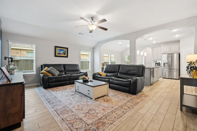 16863 Big Reed Dr, Humble, TX 77346 - living area with arched walkways, light wood-type flooring, a ceiling fan, plenty of natural light, and lofted ceiling