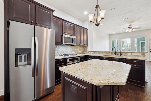 17011 Seminole Ridge Dr, Cypress, TX 77433 - kitchen featuring appliances with stainless steel finishes, a peninsula, dark wood-style floors, tasteful backsplash, and dark brown cabinets