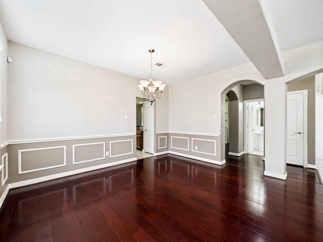 8122 Silver Lure Dr, Humble, TX 77346 - spare room with hardwood / wood-style floors, a chandelier, wainscoting, arched walkways, and a decorative wall