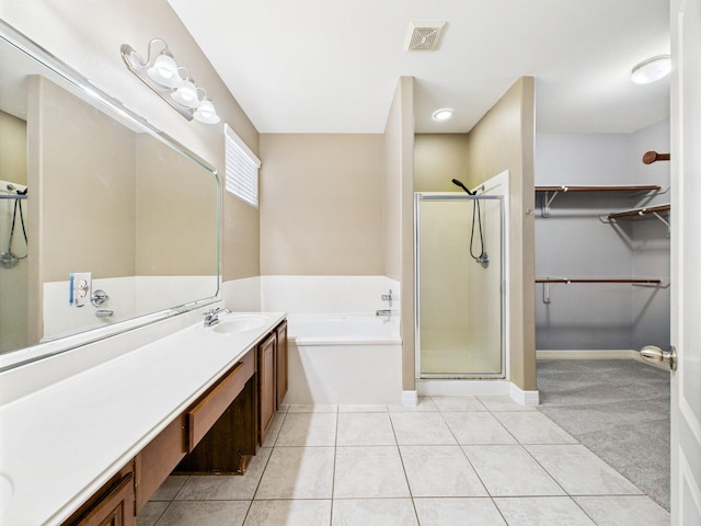 8122 Silver Lure Dr, Humble, TX 77346 - bathroom featuring a garden tub, vanity, a shower stall, a walk in closet, and tile patterned floors