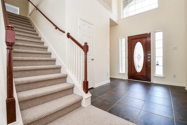 150 Nina Ln, Stafford, TX 77477 - entrance foyer with stairway, plenty of natural light, a high ceiling, and dark tile patterned flooring