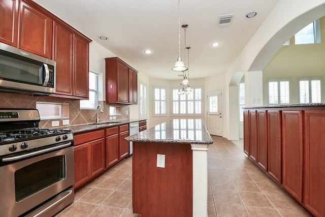 150 Nina Ln, Stafford, TX 77477 - kitchen featuring stainless steel appliances, recessed lighting, a center island, dark stone counters, and decorative backsplash