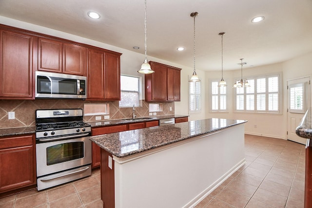 150 Nina Ln, Stafford, TX 77477 - kitchen featuring stainless steel appliances, tasteful backsplash, recessed lighting, dark stone counters, and hanging light fixtures