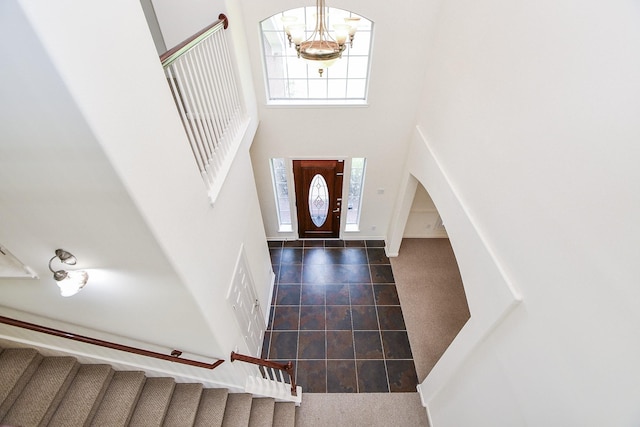 150 Nina Ln, Stafford, TX 77477 - entrance foyer featuring a chandelier, tile patterned floors, a towering ceiling, and arched walkways