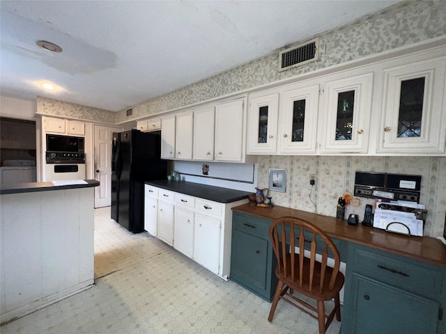 1115 Woodbank Dr, Seabrook, TX 77586 - kitchen featuring light flooring, dark countertops, freestanding refrigerator, white oven, and white cabinets