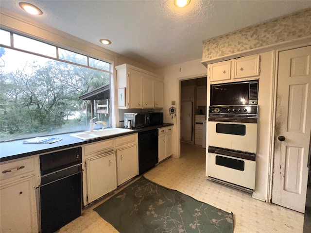 1115 Woodbank Dr, Seabrook, TX 77586 - kitchen with black appliances, light floors, dark countertops, recessed lighting, and white cabinets